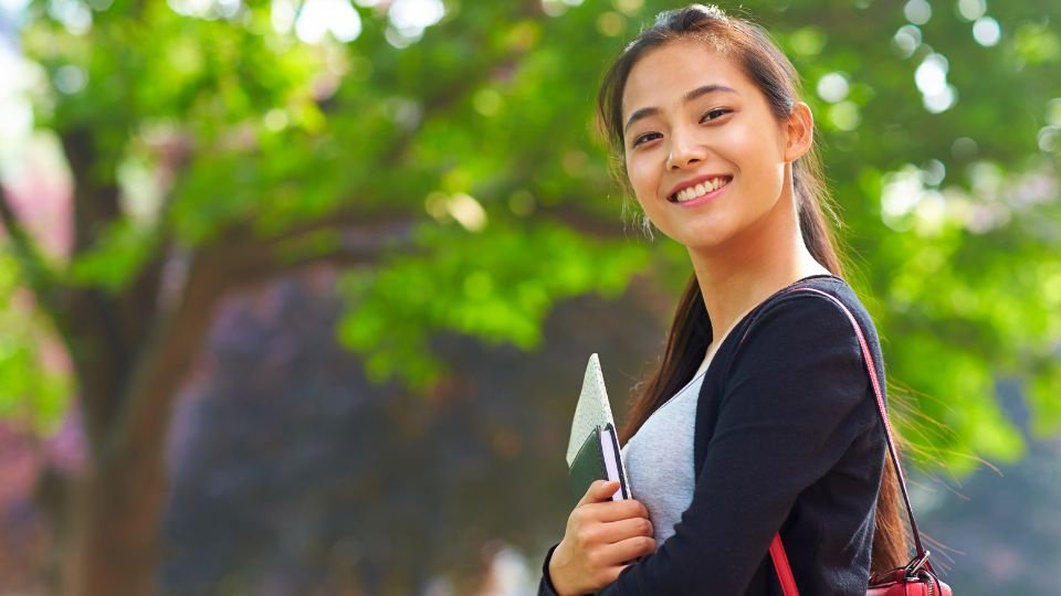 Happy teacher outdoors on a beautiful day educating students on AI with the help of an AI teacher assistant